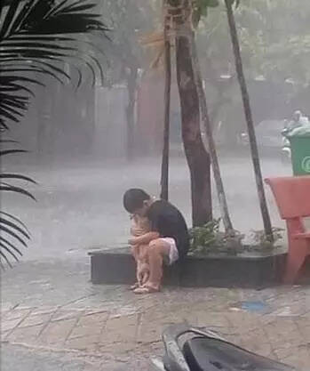 小男孩抱着狗狗在暴雨中告别：对不起...